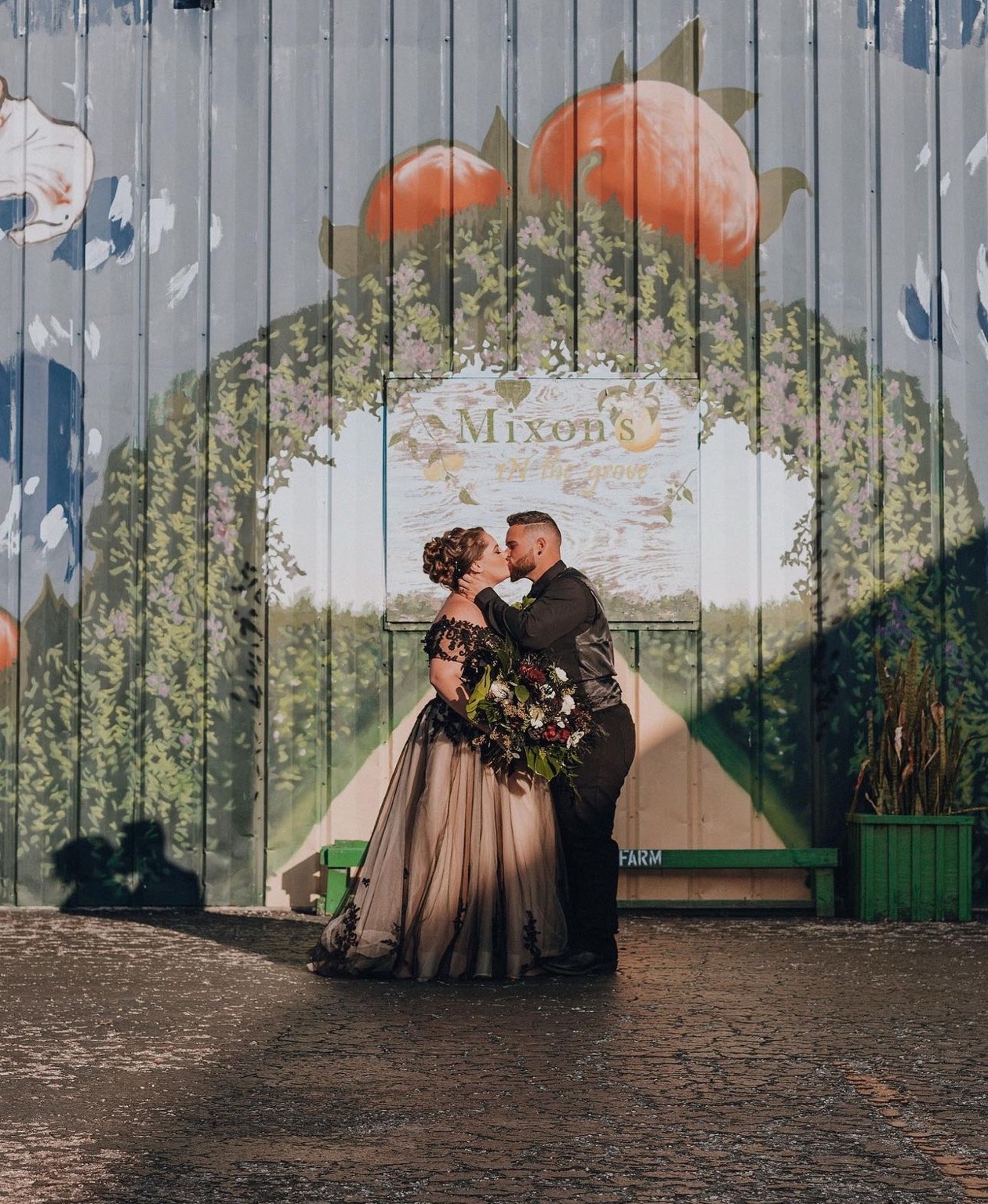 Wedding couple in front of a floral arch