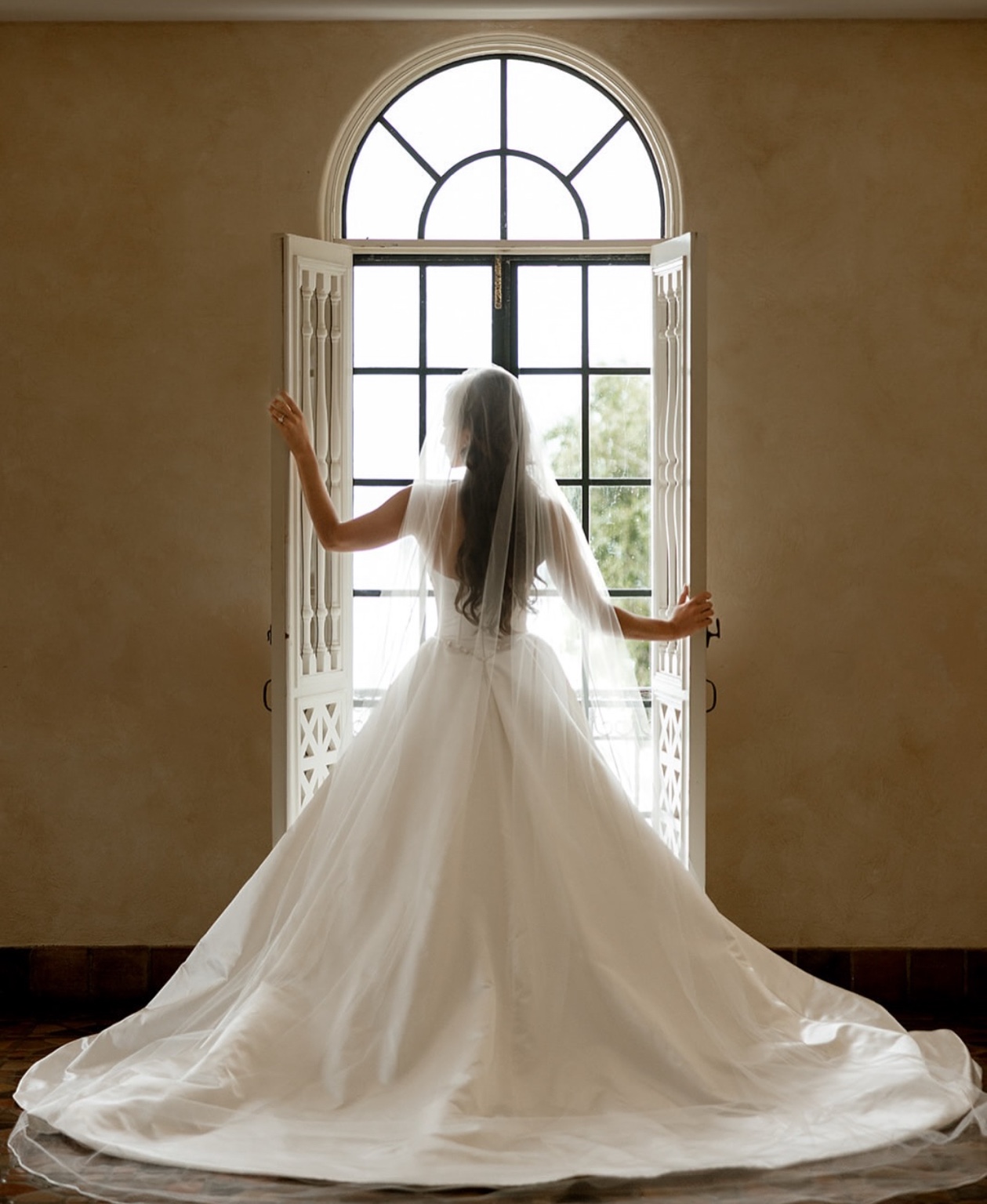 Bride at an arched window in a long veil