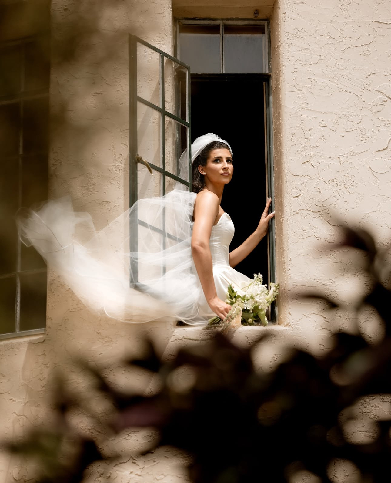 Bride in a white gown and veil at the doorway