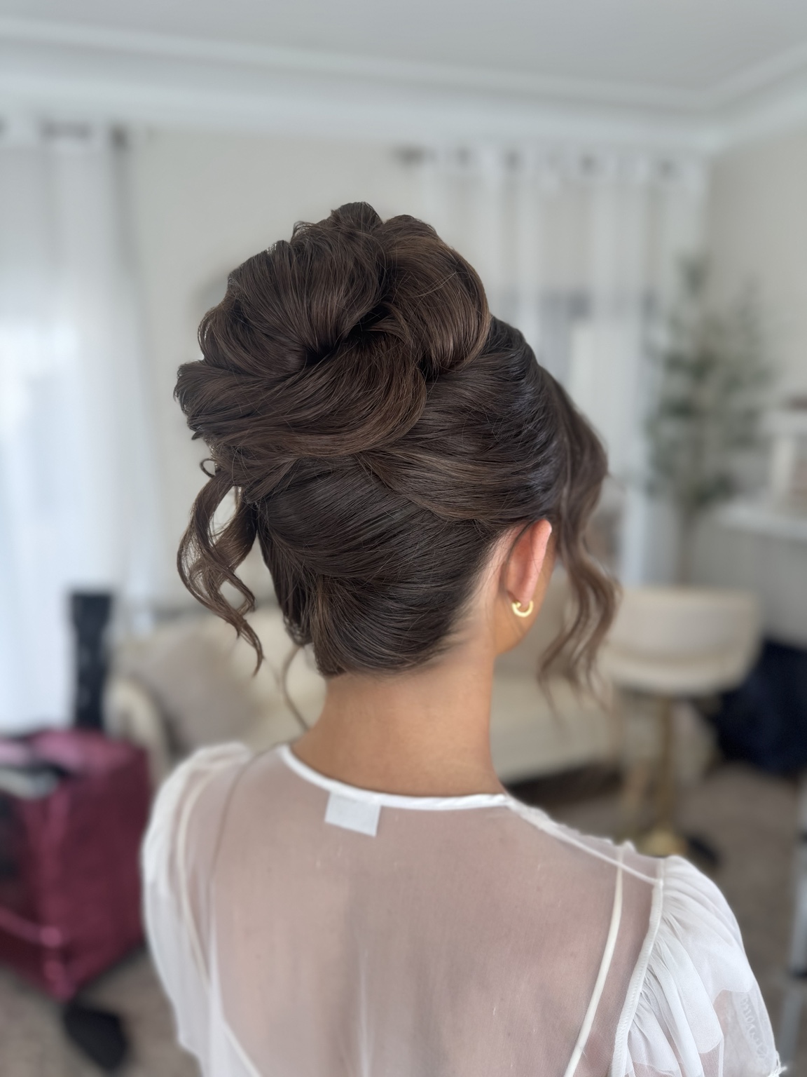 Textured brunette bridal updo with soft face-framing pieces